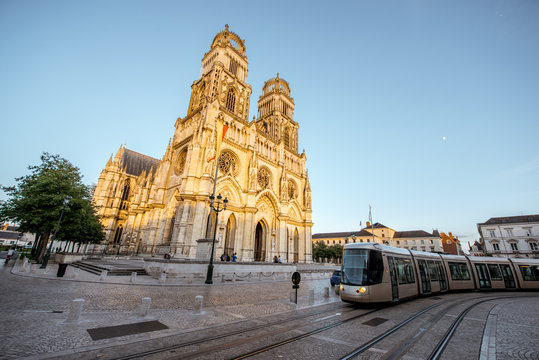 Street view on the saint Croix cathedral with tram in Orleans city during the sunset in central France