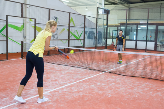 couple playing tennis game indoor