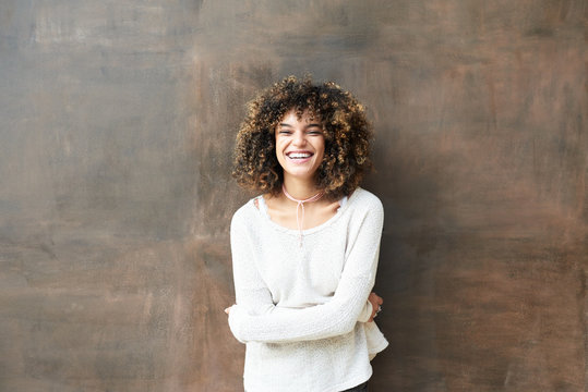 Laughing brunette woman embracing herself