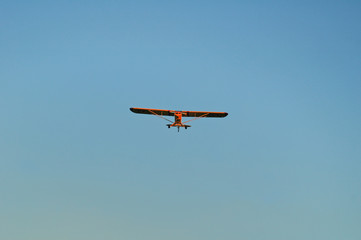 Fototapeta na wymiar yellow single engine monoplane approaching for landing