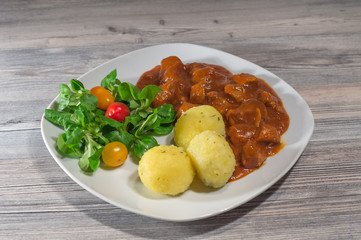 Gulasch mit Salat und Kartoffelknödel