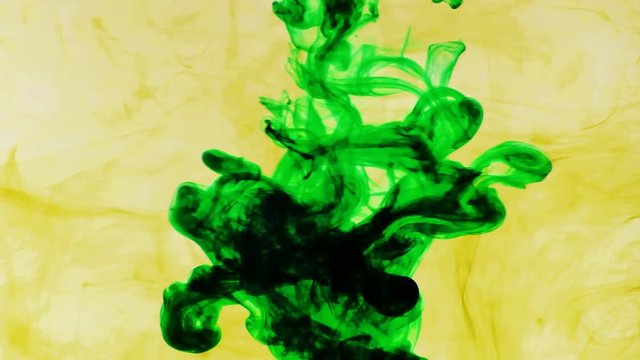 Green and yellow ink moving in water with white background in 4K resolution