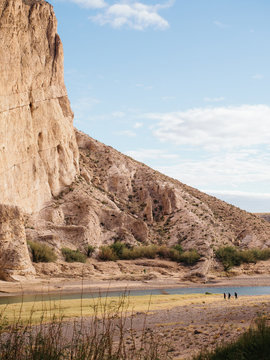 Three anonymous hikers dwarfed by landscape on the US Mexico border