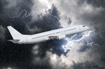 White passenger airplane takes off during a thunderstorm of rain, bad weather