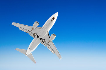 White passenger airplane in the blue sky