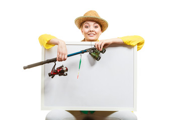 Happy woman with fishing rod holding board