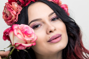 Obraz na płótnie Canvas Beauty Fashion Model Woman face. Portrait with Red Rose flower. Red Lips and Nails. Beautiful Brunette Woman with Luxury Makeup and Manicure.