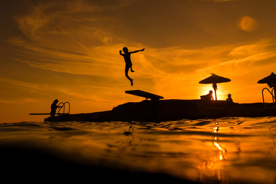 People jumping from sea floating platform