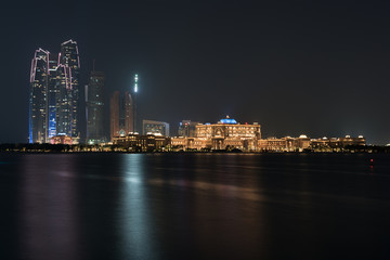 Obraz premium Abu Dhabi buildings skyline from the sea at night