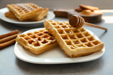 Tasty homemade waffles with honey on plate