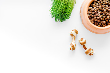 bowl full and overflowing with dry pet - dog food bits and toys on white background top view mock-up