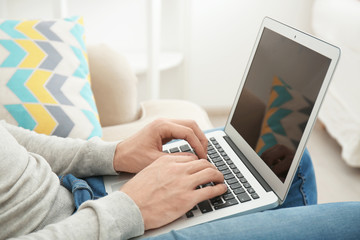 Naklejka premium Young man working with laptop at home