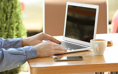 Young man working with laptop at table