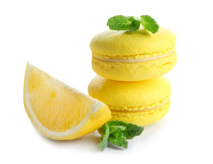 Fototapeta na wymiar Lemon macarons with sliced fruit and mint leaves on white background