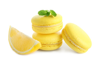 Lemon macarons with sliced fruit and mint leaves on white background