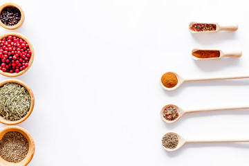 Kitchen table with spices and dry herbs on white kitchen background top view mock up