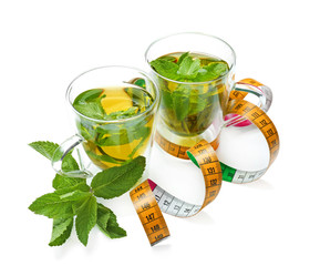 Cups of tea and measuring tape on white background. Weight loss concept
