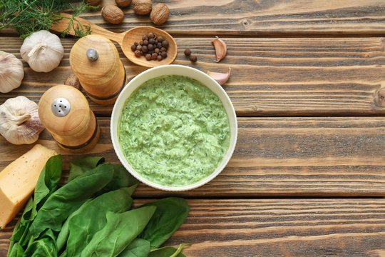 Bowl with tasty spinach sauce on table