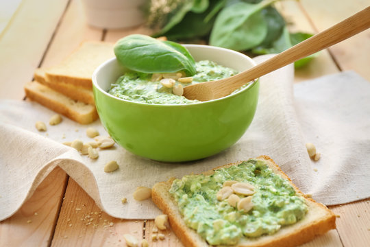 Bowl with tasty spinach sauce on table