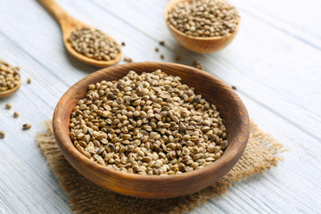 Bowl with hemp seeds on wooden background