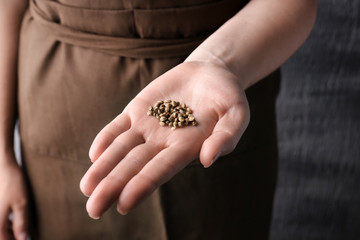 Young woman holding hemp seeds, closeup