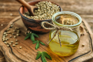Composition with hemp oil and seeds on wooden table