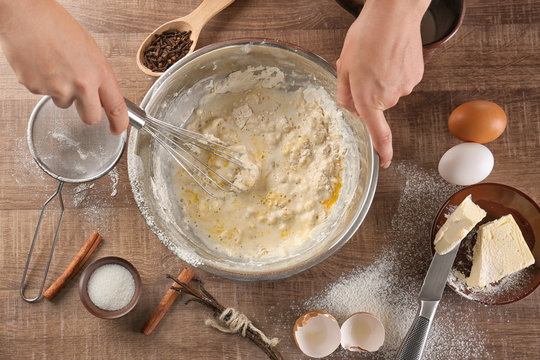 Woman making dough for vanilla cake in kitchen