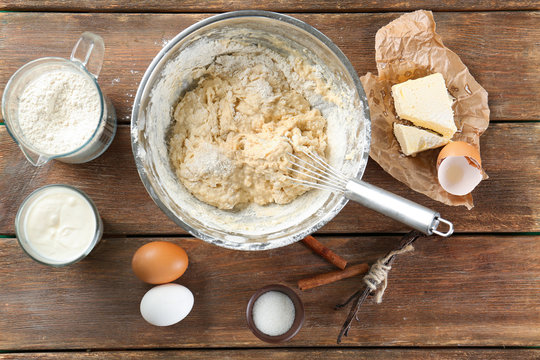Cooking dough for vanilla cake on wooden background