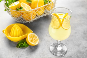 Composition with glass of lemon juice and fresh lemons on table