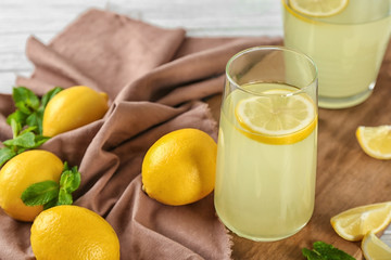 Composition with glasses of lemon juice and fresh lemons on table