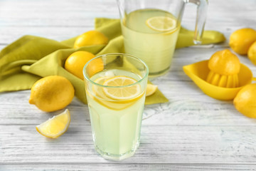Fototapeta premium Composition with glass of lemon juice and fresh lemons on table