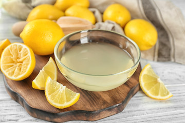 Composition with freshly squeezed lemon juice and lemons on table