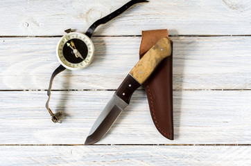 Outdoor composition with a knife and compass on a white background.