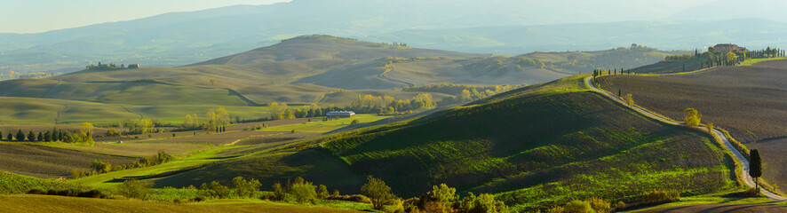 Wavy fields in Tuscany at sunset, Italy. Panoramic view. Natural outdoor seasonal autumn background.