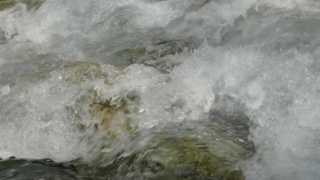 Water in a mountain river in slow motion video.