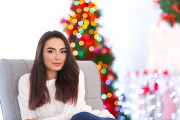 Attractive young lady on armchair at home