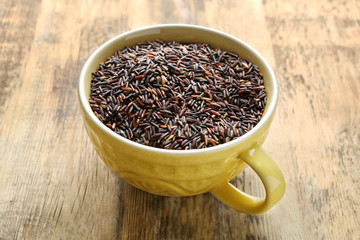 Cup of brown rice on table