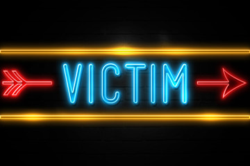 Naklejka na ściany i meble Victim - fluorescent Neon Sign on brickwall Front view