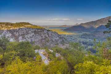 вид с горы на скадарское озеро в национальном парке и на серпантин дороги  © lufotolab