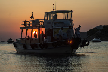 People ride on a boat in the sea during sunset. Fishermen. Travellers