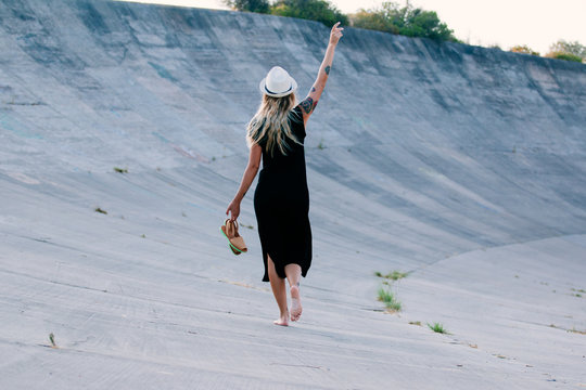Woman with a black dress walking her back to the camera