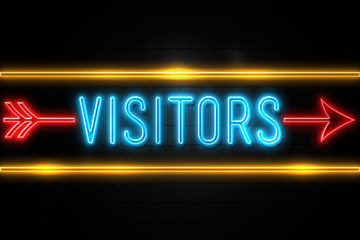 Fototapeta premium Visitors - fluorescent Neon Sign on brickwall Front view