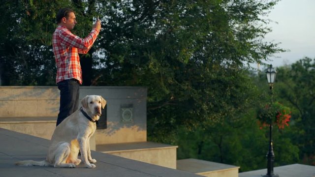 Boy with labrador dog take picture of sunset city park rapid slow motion