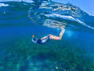 Foto op Aluminium Snorkeling woman dives to sea bottom. Snorkeling girl in full-face snorkeling mask. © Elya.Q