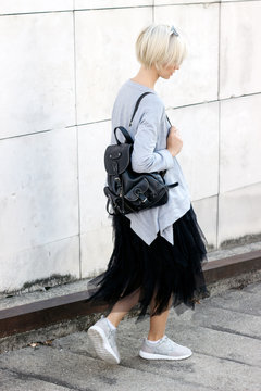 Blond short hair female mode in modern outfit from behind