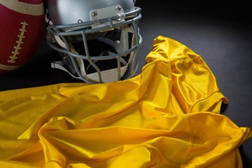 Close-up of American football jersey, head gear and football
