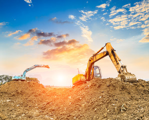 Excavator working at construction site on sunset