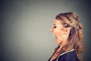 Side profile of an angry young woman screaming