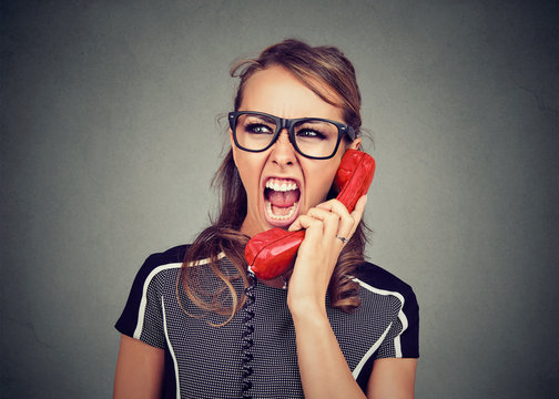 Young woman yelling on the red phone