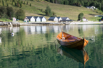 Wooden rowing boat  and boathouses in the background